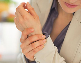 femme qui se tient le bras à cause de l'arthrose